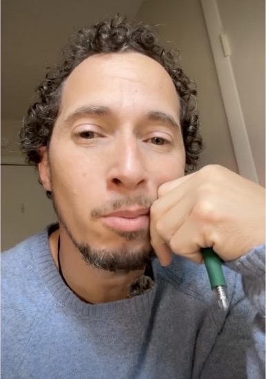 Opening frame of a creator speaking to camera while holding a green pen